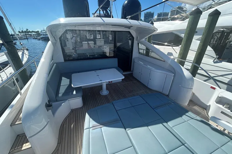 Habeas Orcas Yacht Photos Pics Luxurious 2020 Pershing 62 yacht deck with seating and table, docked at marina.