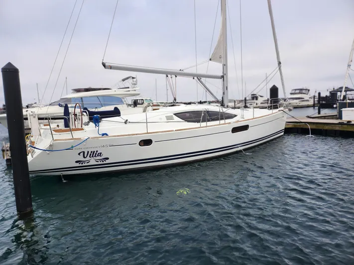 Vilia Yacht Photos Pics 2010 Jeanneau 45DS sailboat docked in marina, overcast sky, calm water.