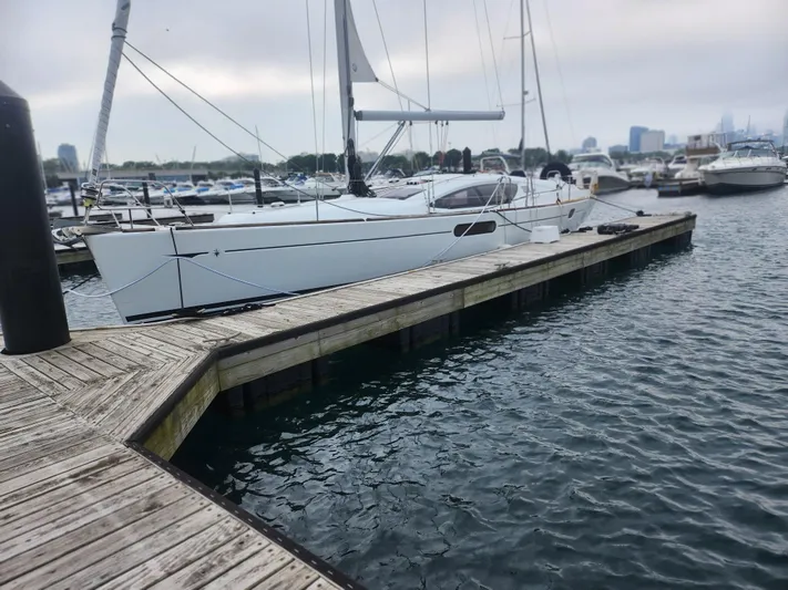 Vilia Yacht Photos Pics 2010 Jeanneau 45DS sailboat docked at marina, calm water, overcast sky.