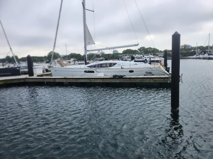 Vilia Yacht Photos Pics 2010 Jeanneau 45DS sailboat docked at a marina on a cloudy day.