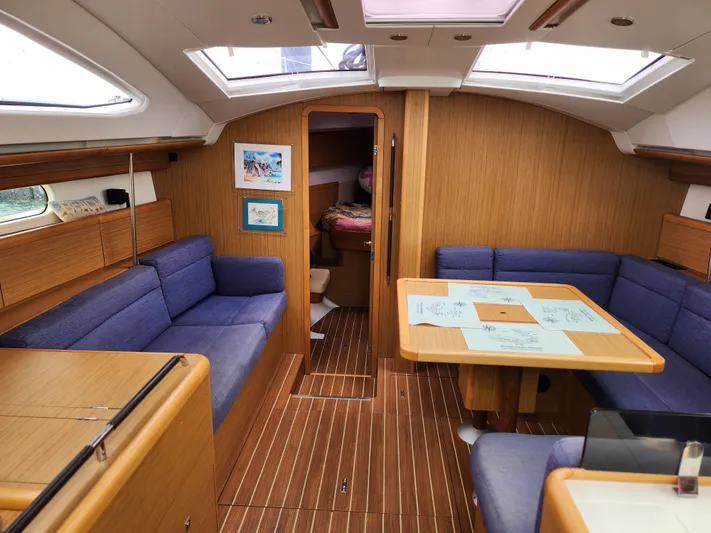 Vilia Yacht Photos Pics Interior of 2010 Jeanneau 45DS sailboat with wood finish and blue seating.