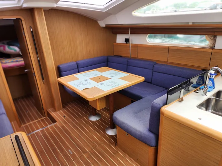 Vilia Yacht Photos Pics Interior of 2010 Jeanneau 45DS sailboat with wooden flooring and blue seating.
