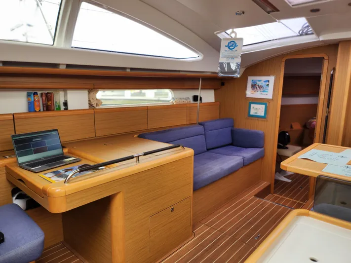 Vilia Yacht Photos Pics Interior of 2010 Jeanneau 45DS yacht with wooden finish and blue seating.