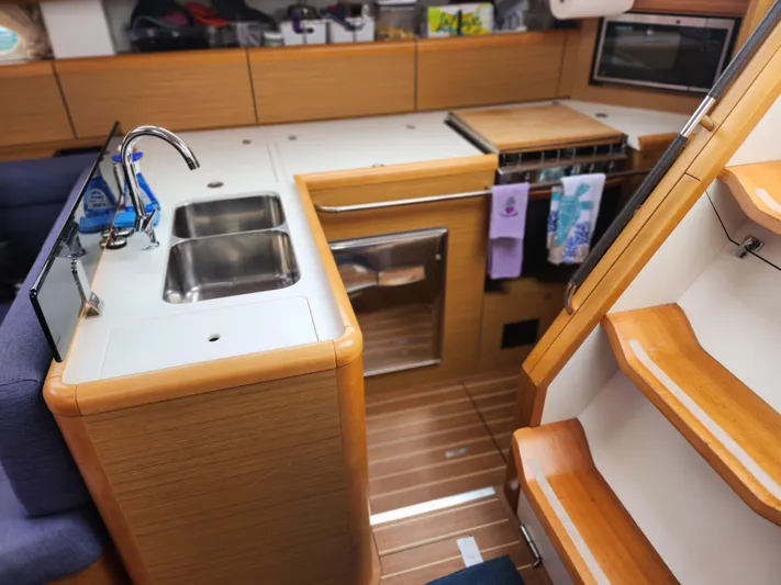 Vilia Yacht Photos Pics Modern kitchen interior of 2010 Jeanneau 45DS yacht with wooden cabinetry and stainless steel sink.