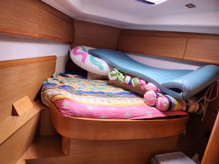 Vilia Yacht Photos Pics Cozy cabin interior of 2010 Jeanneau 45DS sailboat with colorful bedding and inflatables.