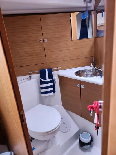 Vilia Yacht Photos Pics 2010 Jeanneau 45DS yacht bathroom with wood cabinetry, sink, and toilet.