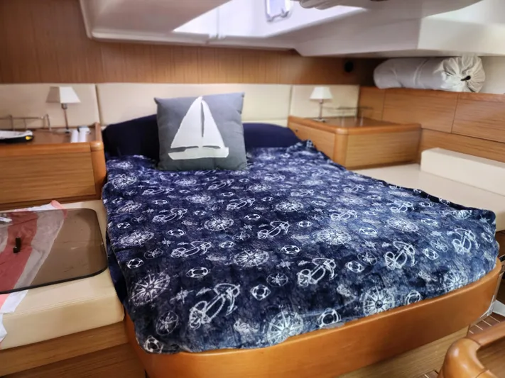Vilia Yacht Photos Pics Cozy cabin interior of 2010 Jeanneau 45DS sailboat with nautical-themed bedding.