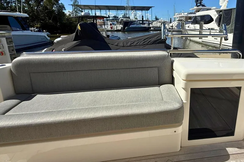 Buzz Yacht Photos Pics 2020 Riviera 57 Enclosed Flybridge yacht with gray seating at marina.