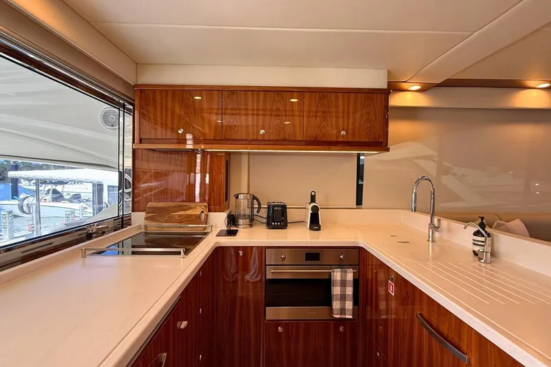 Buzz Yacht Photos Pics Luxurious kitchen interior of 2020 Riviera 57 Enclosed Flybridge yacht with modern appliances.