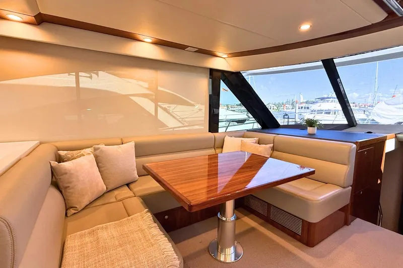 Buzz Yacht Photos Pics Luxurious interior of 2020 Riviera 57 Enclosed Flybridge yacht with elegant seating and table.