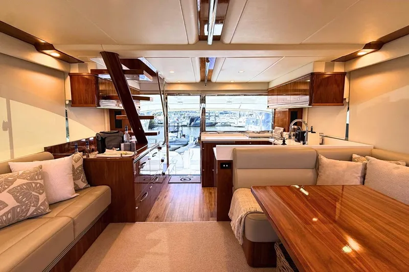 Buzz Yacht Photos Pics Luxurious interior of 2020 Riviera 57 Enclosed Flybridge yacht with elegant wood finishes.