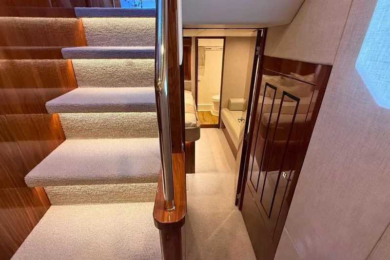 Buzz Yacht Photos Pics Luxurious interior of 2020 Riviera 57 Enclosed Flybridge yacht with carpeted stairs.