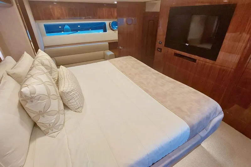 Buzz Yacht Photos Pics Luxurious bedroom interior of 2020 Riviera 57 Enclosed Flybridge yacht with elegant furnishings.