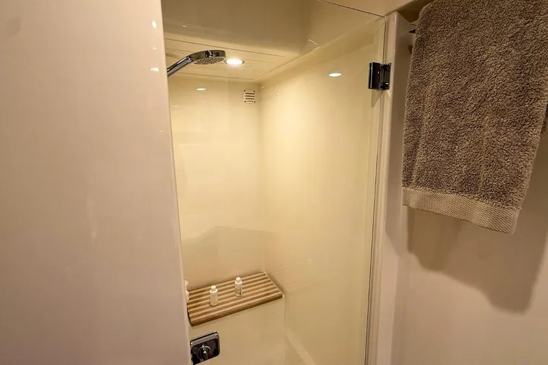 Buzz Yacht Photos Pics Shower area in 2020 Riviera 57 Enclosed Flybridge yacht, featuring modern fixtures and towel.