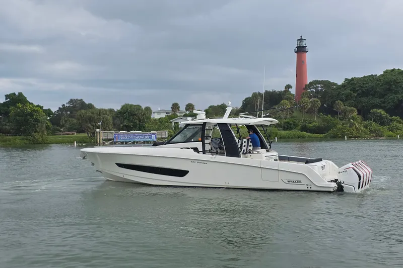 Bft Yacht Photos Pics 2021 Boston Whaler 420OR boat cruising near a lighthouse on a cloudy day.