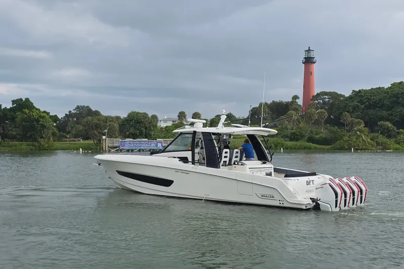 Bft Yacht Photos Pics 2021 Boston Whaler 420OR boat cruising near a lighthouse on a cloudy day.