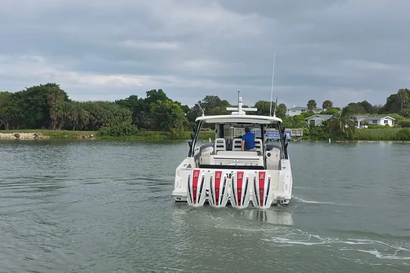 Bft Yacht Photos Pics 2021 Boston Whaler 420OR boat cruising on a calm lake with lush greenery.