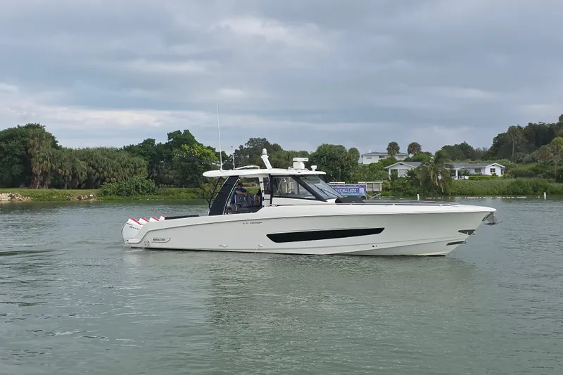 Bft Yacht Photos Pics 2021 Boston Whaler 420OR boat cruising on a calm waterway with lush greenery.