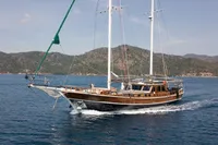 Aganlar Custom Motorsailer Gulet 2003 sailing on calm blue waters near a mountainous coastline.