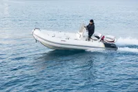Aganlar Custom Motorsailer Gulet 2003 on calm water, person steering, Evinrude motor visible.