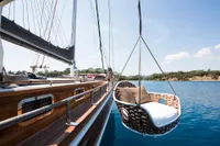 Aganlar Custom Motorsailer Gulet 2003 with hanging wicker chair over calm blue water.