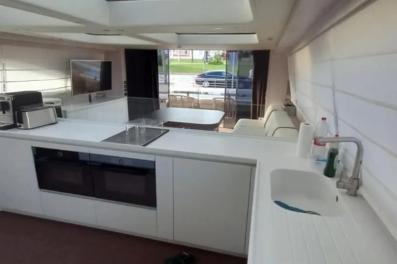  Yacht Photos Pics Modern yacht interior with sleek kitchen design, featuring white countertops and appliances. AB 88, 2005 model.