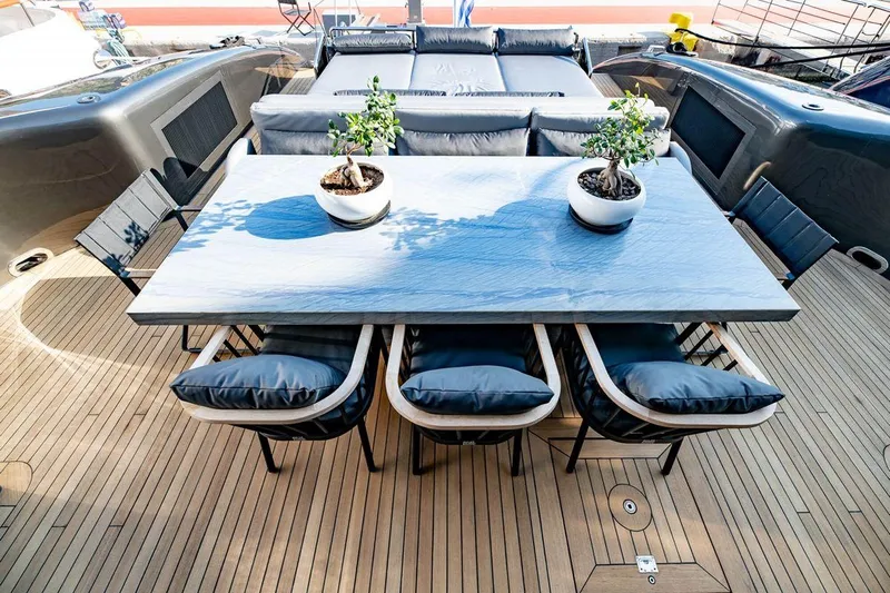 Eva Yacht Photos Pics Luxurious outdoor dining area on Tecnomar Velvet 36 EVA yacht, featuring elegant seating and potted plants.
