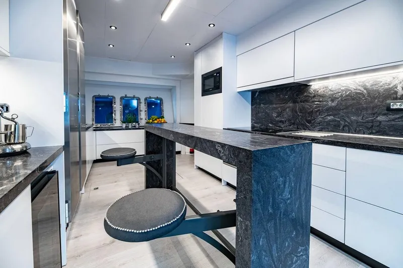 Eva Yacht Photos Pics Modern yacht kitchen with sleek black countertops, integrated appliances, and stylish seating. Tecnomar Velvet 36 EVA.