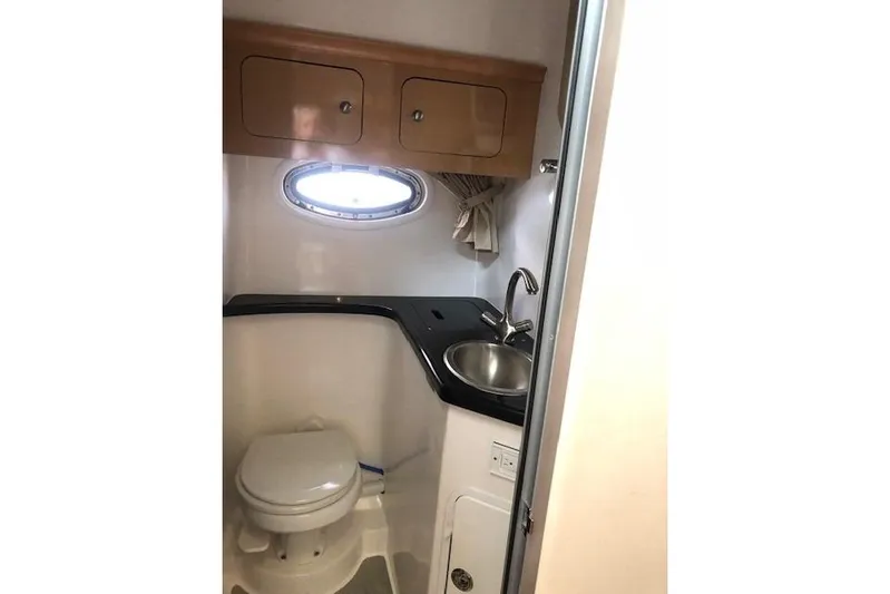  Yacht Photos Pics 2010 Rinker 400 Express Cruiser bathroom with sink, toilet, and storage cabinets.