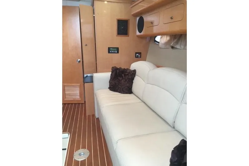  Yacht Photos Pics Interior of 2010 Rinker 400 Express Cruiser with white leather seating and wooden cabinetry.