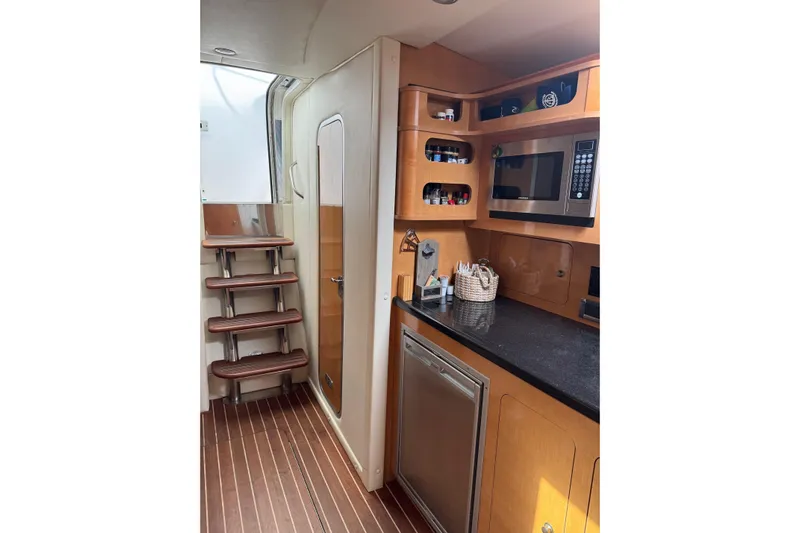  Yacht Photos Pics 2010 Rinker 400 Express Cruiser interior with kitchenette, microwave, and wooden stairs.