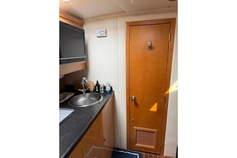  Yacht Photos Pics Interior of 2010 Rinker 400 Express Cruiser with sink and wooden door.