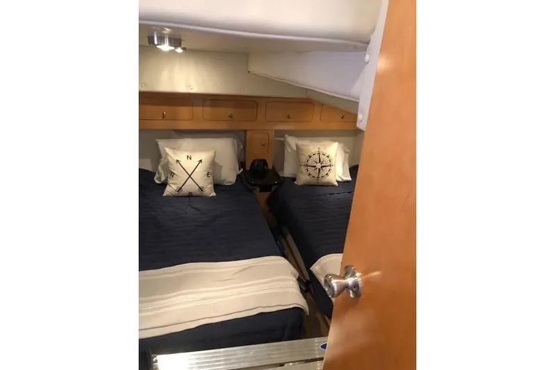  Yacht Photos Pics 2010 Rinker 400 Express Cruiser cabin with twin beds and nautical-themed pillows.