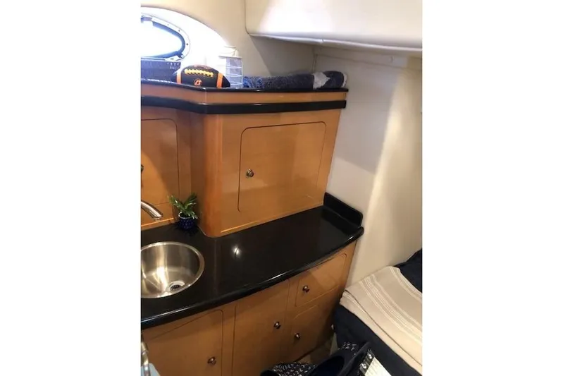  Yacht Photos Pics 2010 Rinker 400 Express Cruiser interior with wooden cabinetry and black countertop.