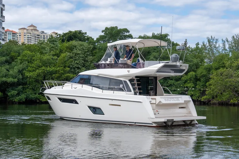  Yacht Photos Pics 2018 Ferretti Yachts 450 Fly cruising on a scenic waterway with lush greenery.