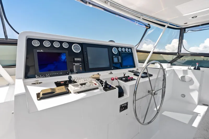 Bravo Zulu Yacht Photos Pics Control panel of a 1997 Westship Raised Pilothouse Motor Yacht with steering wheel and navigation screens.