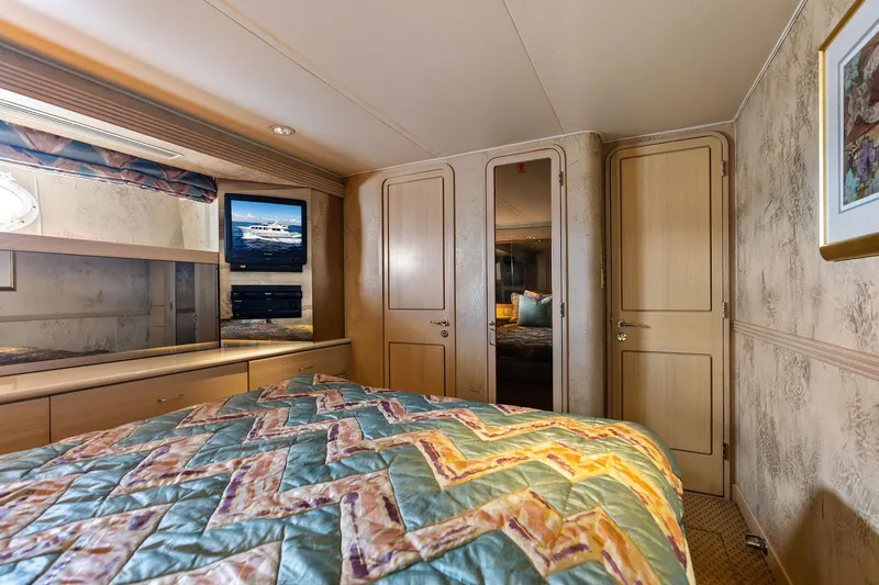 Bravo Zulu Yacht Photos Pics Luxurious bedroom interior of 1997 Westship Raised Pilothouse Motor Yacht with TV and patterned bedding.