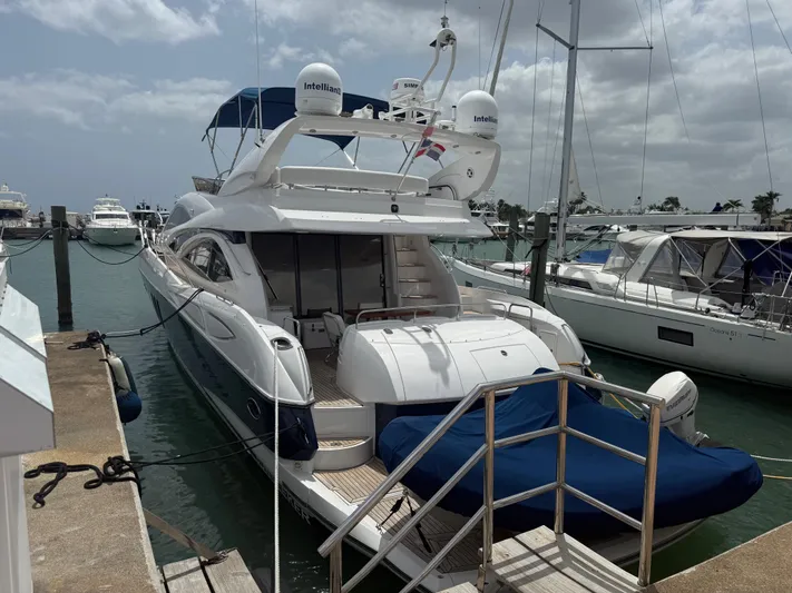 Sunshine Yacht Photos Pics 2004 Sunseeker Manhattan 64 yacht docked at marina under cloudy sky.