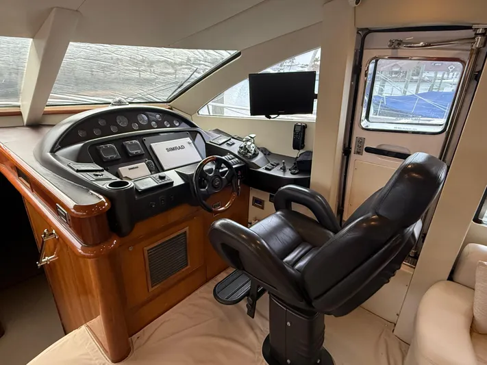 Sunshine Yacht Photos Pics Luxurious helm of 2004 Sunseeker Manhattan 64 yacht with leather captain's chair and navigation equipment.