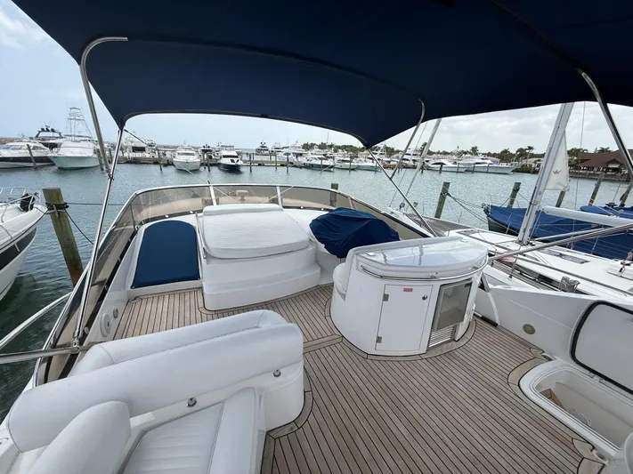 Sunshine Yacht Photos Pics 2004 Sunseeker Manhattan 64 yacht deck with seating, docked at marina.