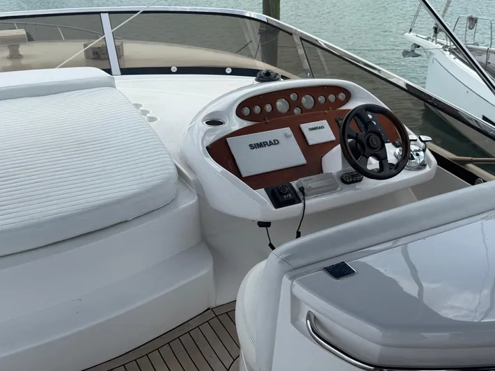Sunshine Yacht Photos Pics 2004 Sunseeker Manhattan 64 yacht helm with Simrad navigation system and white seating.