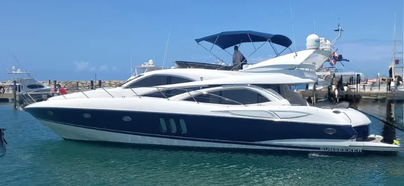 Sunshine Yacht Photos Pics 2004 Sunseeker Manhattan 64 yacht docked in a marina under clear blue skies.