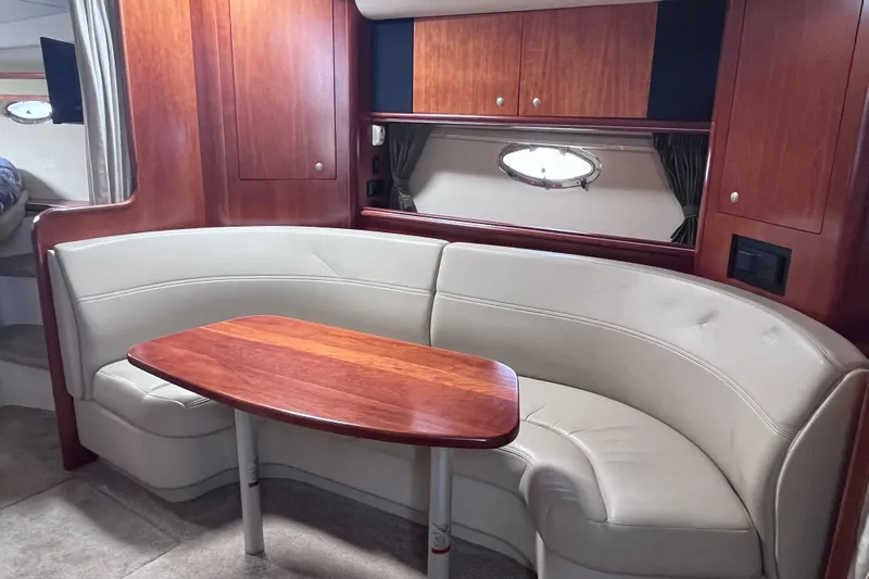  Yacht Photos Pics 2007 Cruisers Yachts 370 Express interior with curved seating and wooden table.
