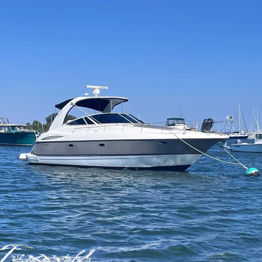  Yacht Photos Pics 2007 Cruisers Yachts 370 Express moored on calm water under clear blue sky.