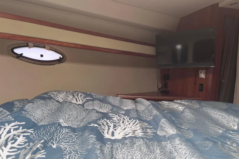  Yacht Photos Pics 2007 Cruisers Yachts 370 Express cabin with TV, porthole, and ocean-themed bedding.