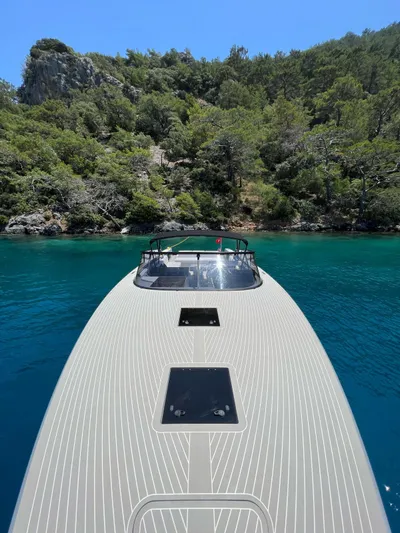  Yacht Photos Pics VanDutch 48 yacht cruising in clear blue waters near a lush, forested coastline.