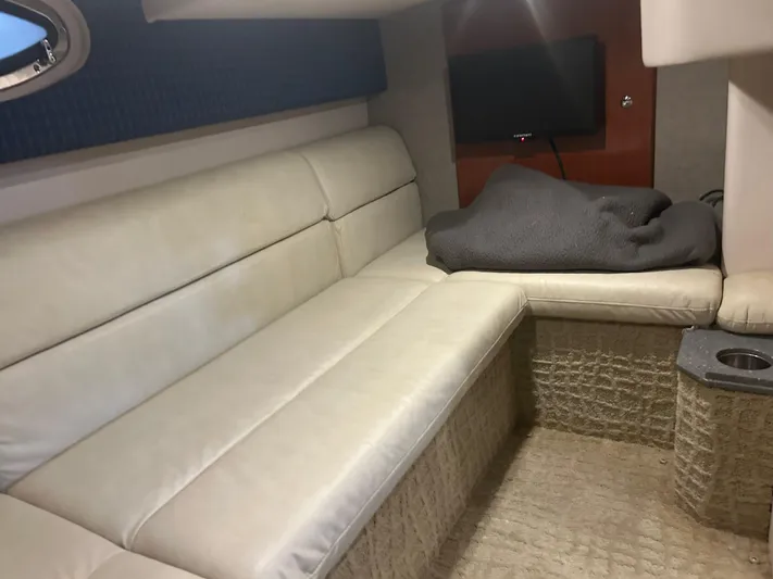  Yacht Photos Pics 2007 Formula 31 PC cabin interior with beige seating and a mounted TV.