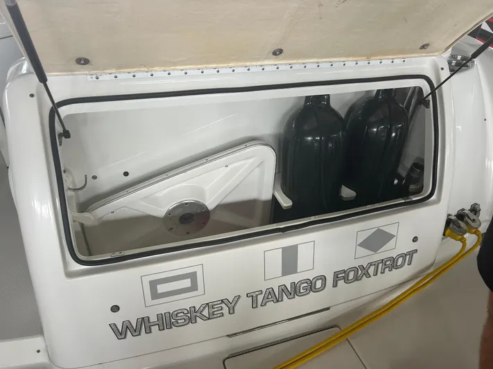  Yacht Photos Pics 2007 Formula 31 PC boat storage compartment with "Whiskey Tango Foxtrot" label and fuel containers.