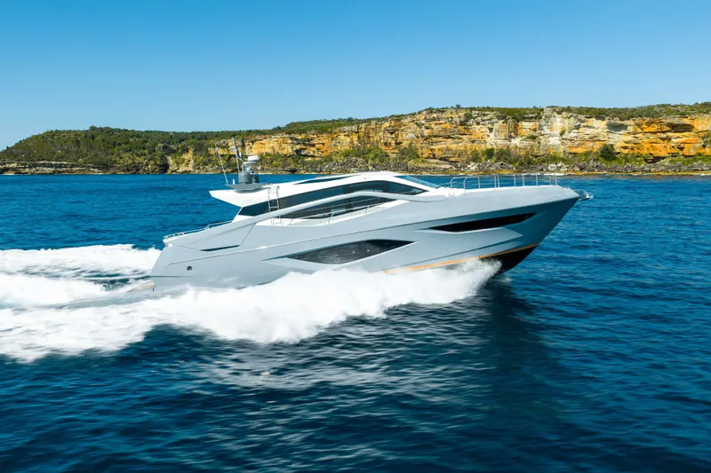 Impulse Yacht Photos Pics 2017 Numarine 62 Hardtop yacht cruising on blue ocean near rocky coastline.