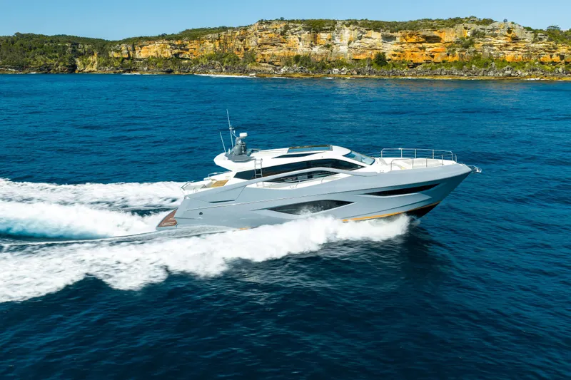 Impulse Yacht Photos Pics 2017 Numarine 62 Hardtop yacht cruising on blue ocean near rocky coastline.